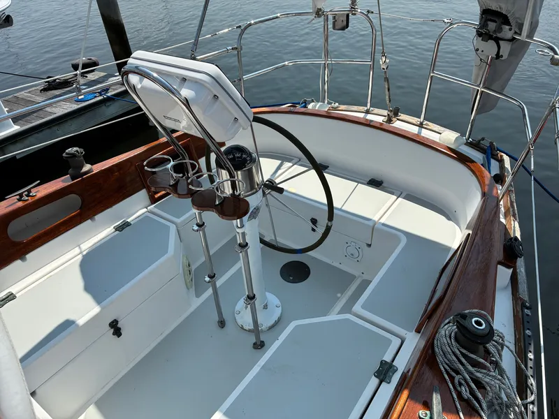 Slide: The Image of The cockpit of a 2001 Cape Dory Robinhood 36 with a steering wheel and wood trim. - 5