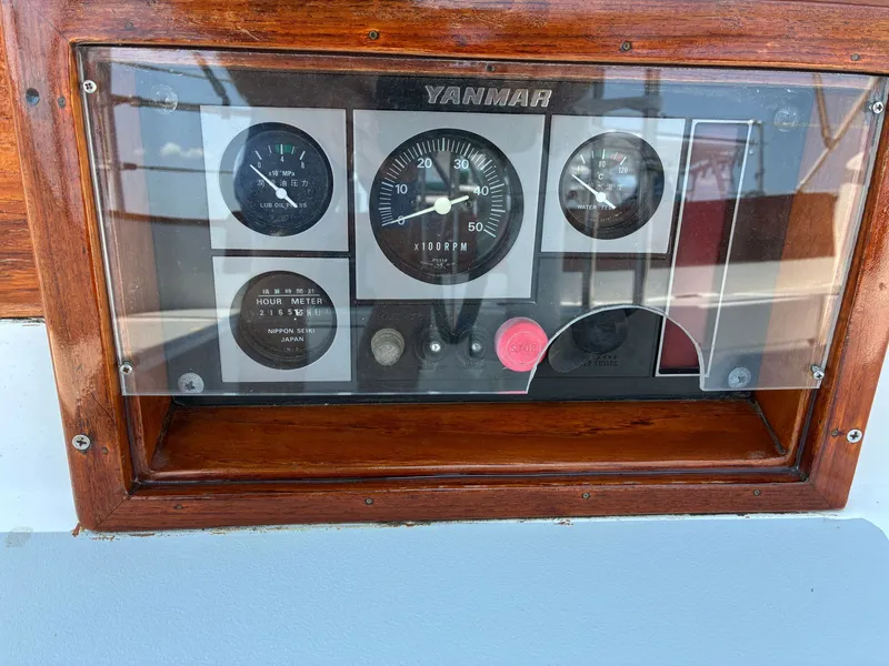 Slide: The Image of The image shows a Yanmar dashboard with various gauges and a red button. - 28