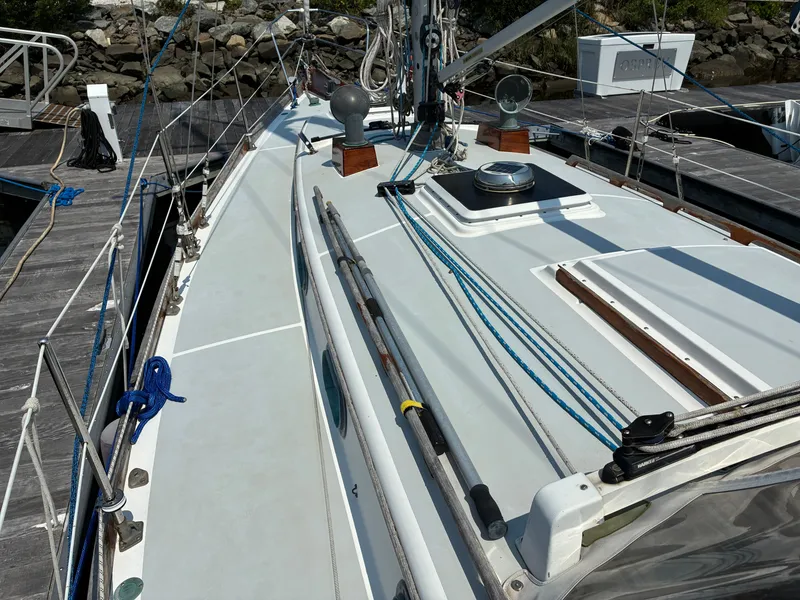 Slide: The Image of The image shows the deck of a 2001 Cape Dory Robinhood 36. It features blue ropes and a mast, docked at a pier. - 8