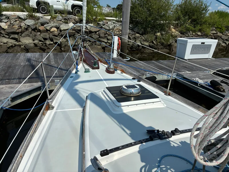 Slide: The Image of The deck of a 2001 Cape Dory Robinhood 36, moored at a dock with ropes and cleats. - 21