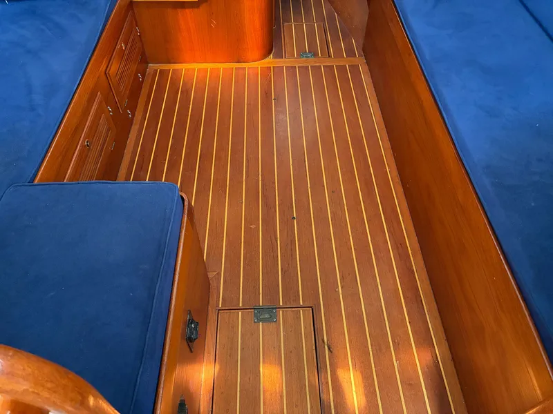 Slide: The Image of Interior of a 2001 Cape Dory Robinhood 36 with wooden flooring and blue upholstery. - 46