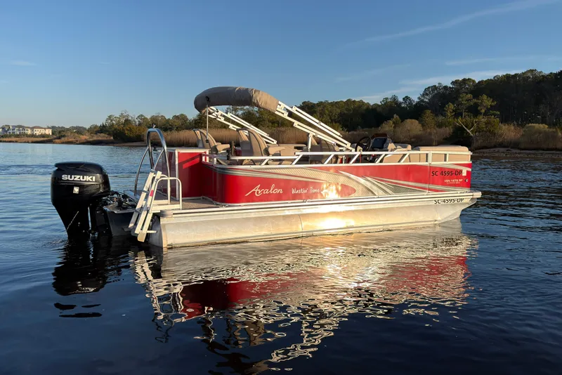 Slide: The Image of 2021 Avalon VENTURE 1875 pontoon boat on calm water with Suzuki outboard motor. - 1