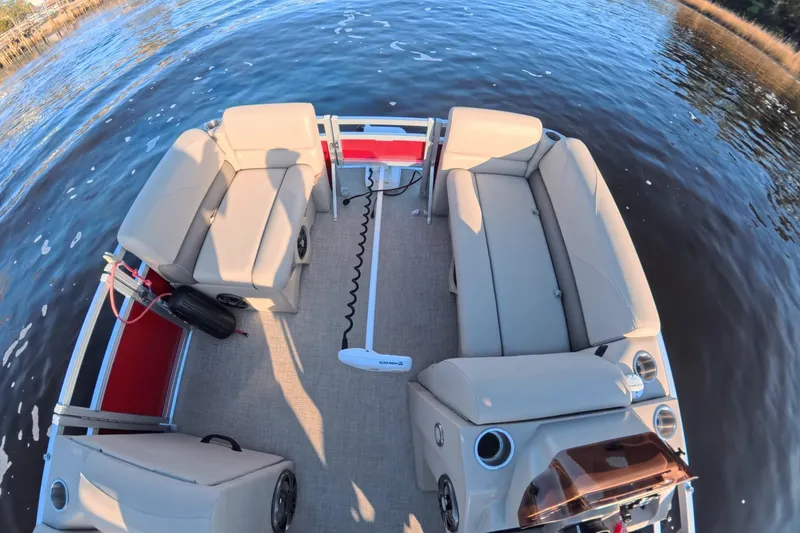 Slide: The Image of 2021 Avalon VENTURE 1875 pontoon boat interior with beige seating on a calm lake. - 24