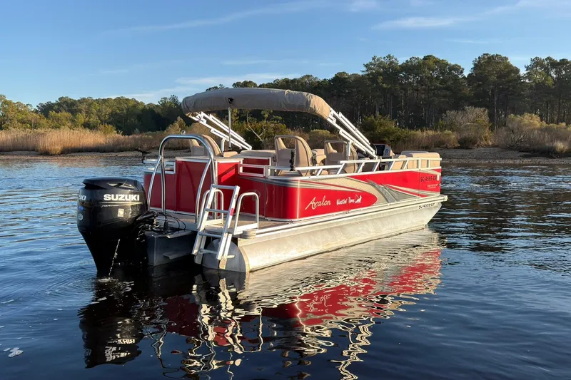 Slide: The Image of 2021 Avalon VENTURE 1875 pontoon boat on calm water with scenic forest backdrop. - 4