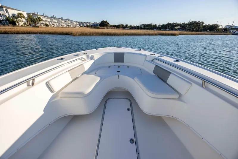 Slide: The Image of 2014 Cape Horn 27 XS boat interior with cushioned seating on calm water. - 11