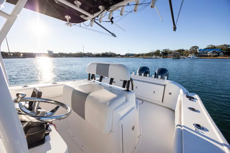Slide: The Image of 2014 Cape Horn 27 XS boat interior with steering wheel, sunny waterfront view. - 15