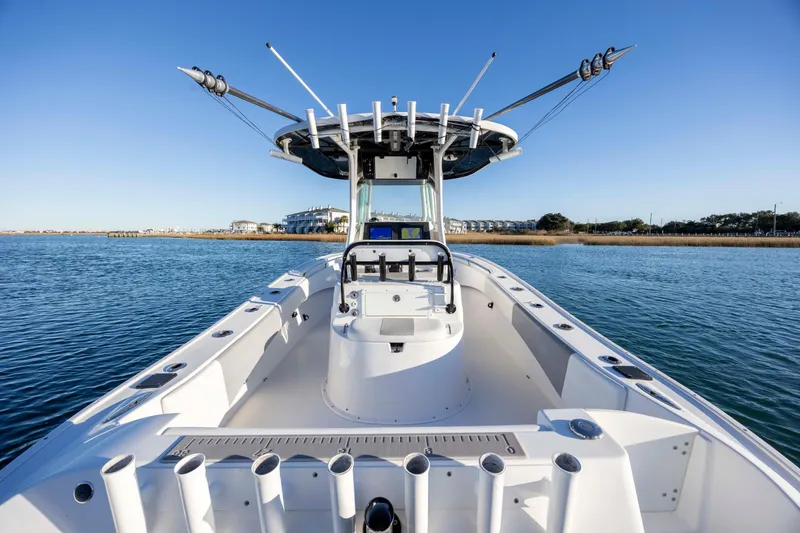 Slide: The Image of 2014 Cape Horn 27 XS boat on calm water, showcasing spacious deck and fishing rod holders. - 26