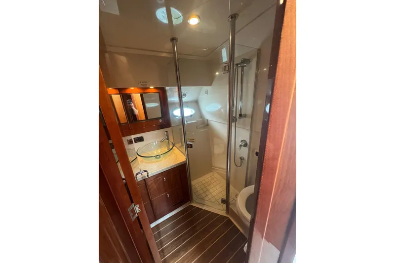 Slide: The Image of Luxurious bathroom in 2009 Riviera 4700 Sport Yacht with modern fixtures and wooden accents. - 10