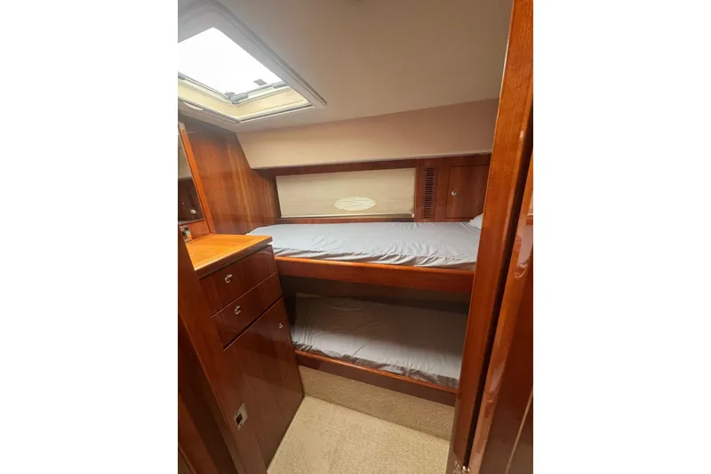 Slide: The Image of Interior cabin of 2009 Riviera 4700 Sport Yacht with wooden finish and bunk beds. - 11