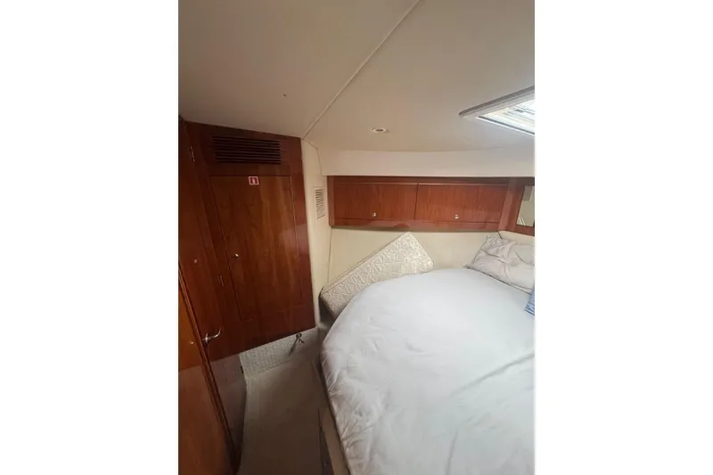 Slide: The Image of Interior cabin of 2009 Riviera 4700 Sport Yacht with wooden cabinetry and bed. - 3