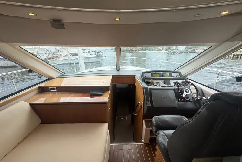 Slide: The Image of Interior view of 2009 Riviera 4700 Sport Yacht helm with leather seating and navigation equipment. - 9