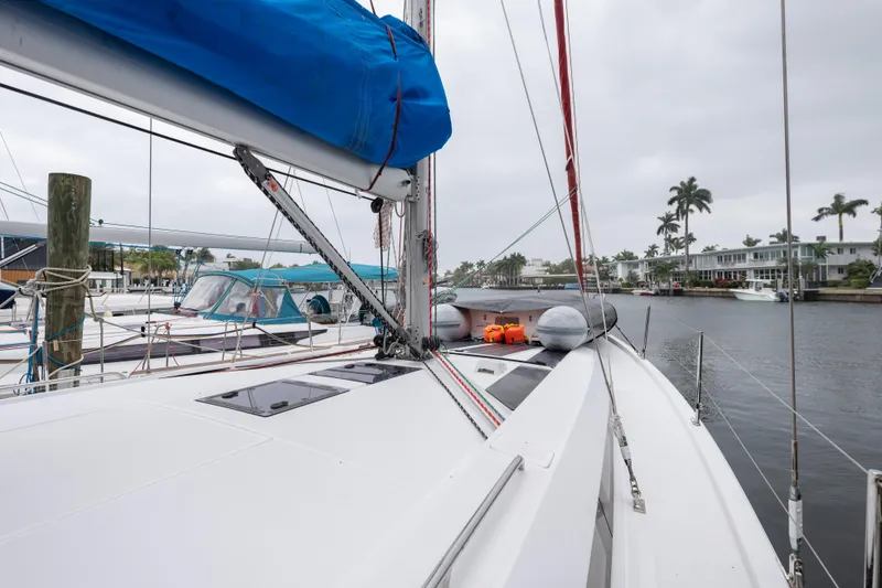 Slide: The Image of 2020 Beneteau Oceanis 46.1 sailboat docked in a marina, featuring a blue sail cover. - 12