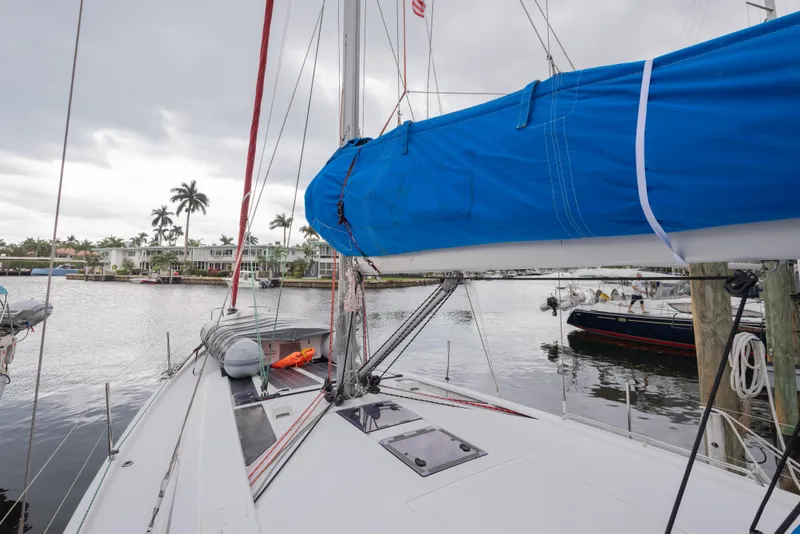Slide: The Image of 2020 Beneteau Oceanis 46.1 sailboat docked in a marina with palm trees. - 13