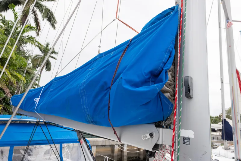 Slide: The Image of 2020 Beneteau Oceanis 46.1 sailboat with blue sail cover, docked near palm trees. - 15