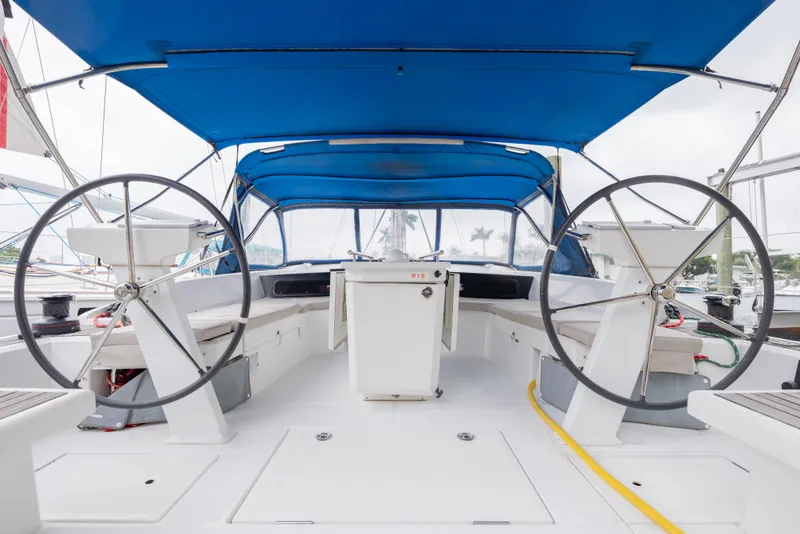 Slide: The Image of 2020 Beneteau Oceanis 46.1 yacht cockpit with dual steering wheels and blue canopy. - 16