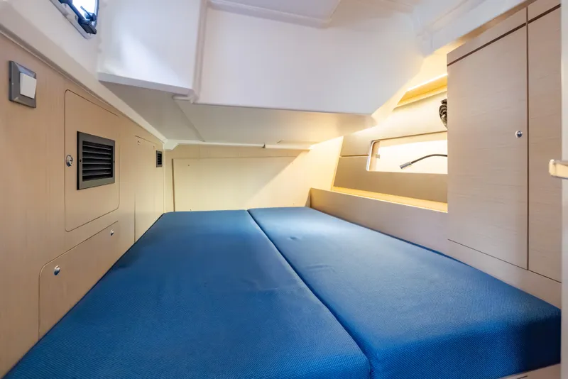 Slide: The Image of Interior cabin of 2020 Beneteau Oceanis 46.1 yacht with blue bedding and wooden cabinetry. - 39