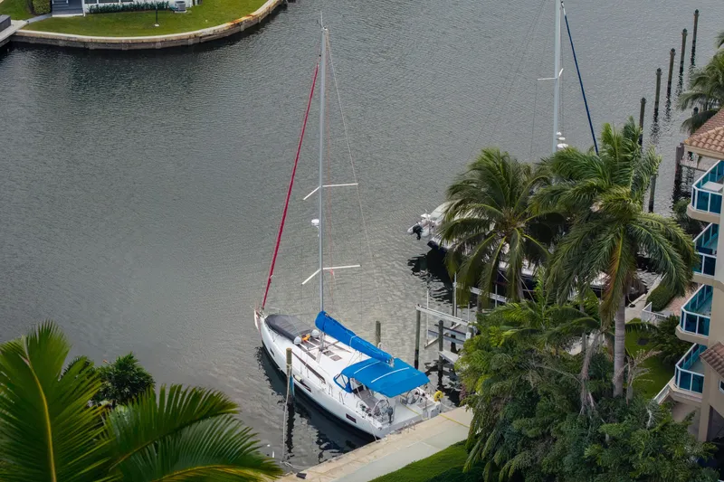 Slide: The Image of 2020 Beneteau Oceanis 46.1 sailboat docked near palm trees in a serene marina. - 41