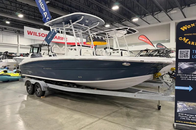The Image of 2026 Stingray 236 CC boat displayed indoors on a trailer at a marine exhibition. - 0