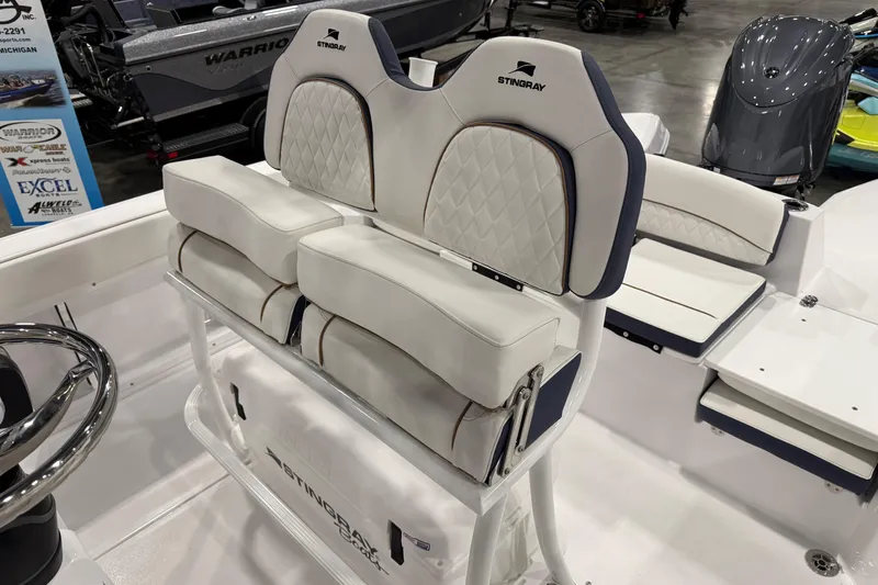 Slide: The Image of 2026 Stingray 236 CC boat interior with white cushioned seating and steering wheel. - 7