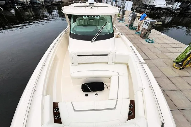 Slide: The Image of 2025 Tiara Yachts 38 LS luxury boat docked, showcasing spacious seating and sleek design. - 11