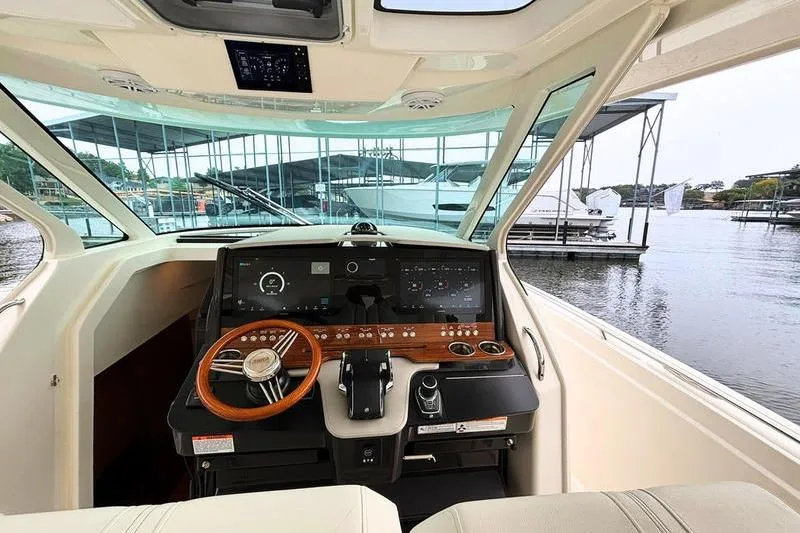 Slide: The Image of 2025 Tiara Yachts 38 LS helm with modern controls, docked at marina. - 13