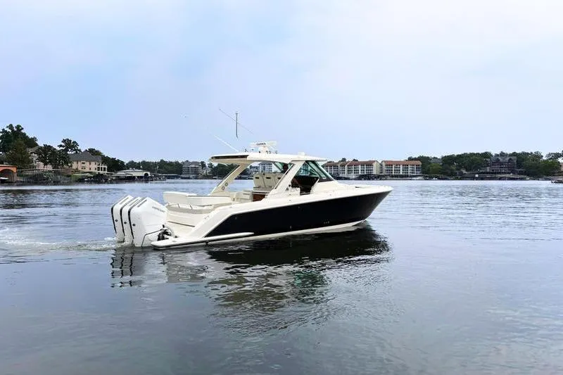 Slide: The Image of 2025 Tiara Yachts 38 LS cruising on a calm lake with scenic background. - 6