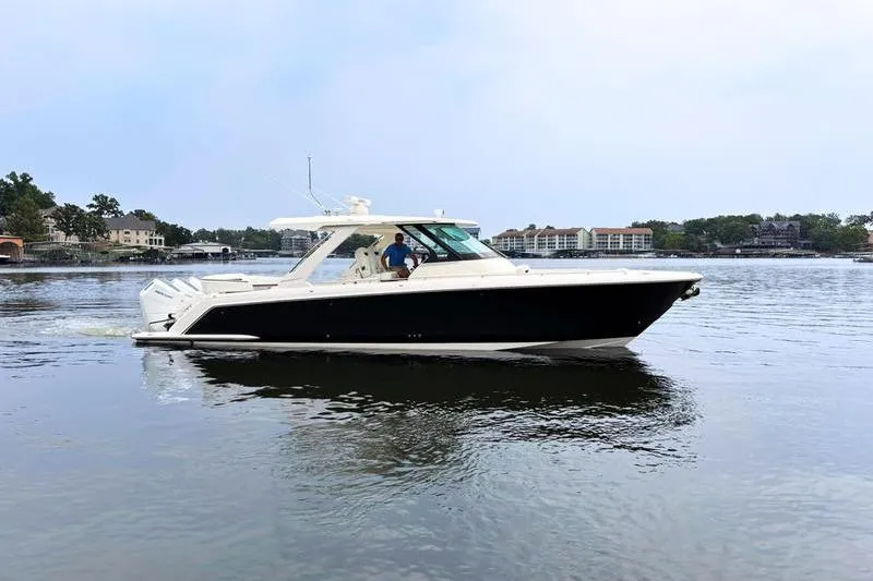 Slide: The Image of 2025 Tiara Yachts 38 LS cruising on a calm lake with scenic background. - 7