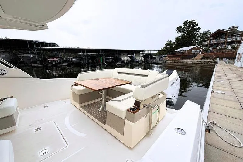 Slide: The Image of 2025 Tiara Yachts 38 LS with elegant seating and table, docked at a marina. - 9