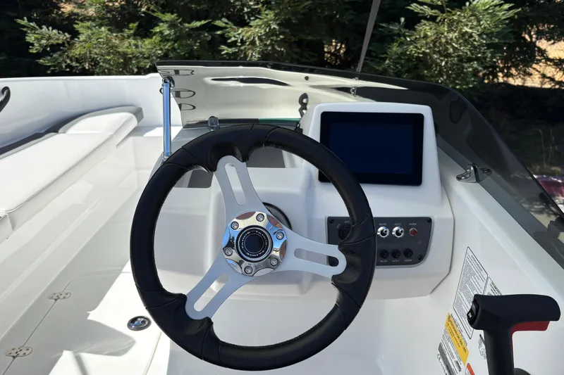 Slide: The Image of Steering wheel and dashboard of 2026 Tahoe T16 boat, featuring modern controls and display. - 17