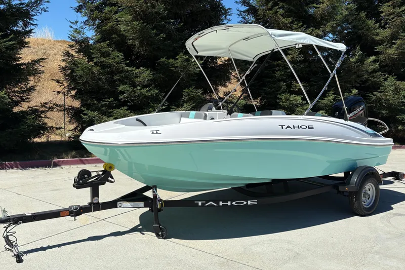 Slide: The Image of 2026 Tahoe T16 boat with canopy on trailer, parked outdoors. - 4