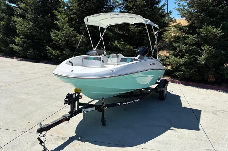 Slide: The Image of 2026 Tahoe T16 boat on trailer, parked outdoors with trees in the background. - 6