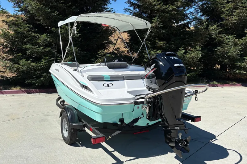 Slide: The Image of 2026 Tahoe T16 boat with Mercury engine on trailer, parked outdoors. - 8