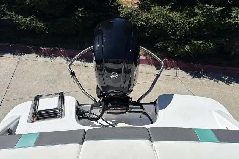 Slide: The Image of 2026 Tahoe T16 boat with outboard motor and swim ladder, parked on concrete. - 11