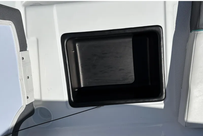 Slide: The Image of A black storage compartment on a white boat, surrounded by upholstery. - 28