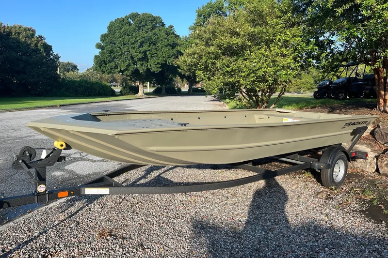 The Image of 2026 Tracker Grizzly 1860 Utility boat on trailer, parked outdoors on gravel. - 0