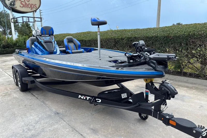 Slide: The Image of 2026 Nitro Z19 XL Pro boat, blue and black, parked on a trailer. - 2