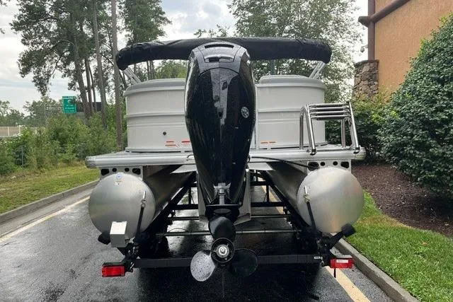 Slide: The Image of 2026 Sun Tracker Party Barge 22 DLX pontoon boat with outboard motor, parked on a trailer. - 3