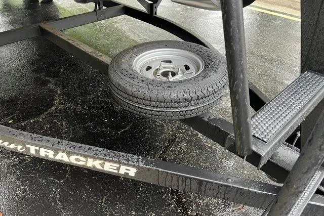 Slide: The Image of Trailer of 2026 Sun Tracker Party Barge 22 DLX with spare tire on wet pavement. - 8