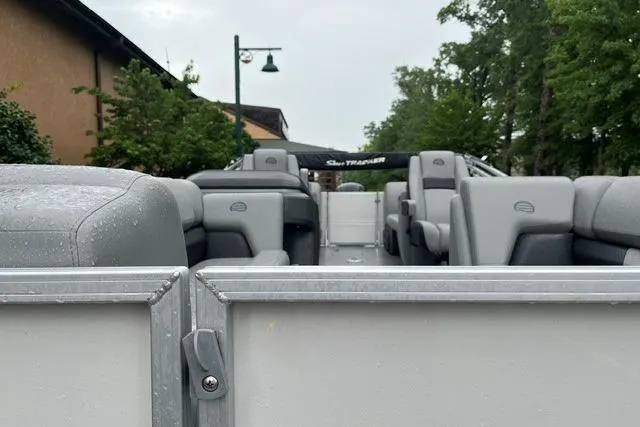 Slide: The Image of 2026 Sun Tracker Party Barge 22 DLX pontoon boat with gray seating, parked outdoors. - 7