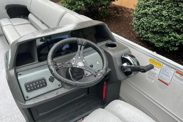 Slide: The Image of 2026 Sun Tracker Party Barge 22 DLX helm with steering wheel and control panel. - 99