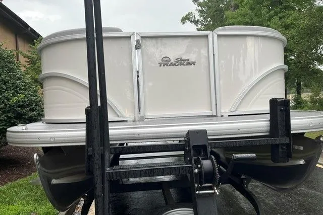 Slide: The Image of 2026 Sun Tracker Party Barge 22 DLX pontoon boat on trailer, parked outdoors. - 4