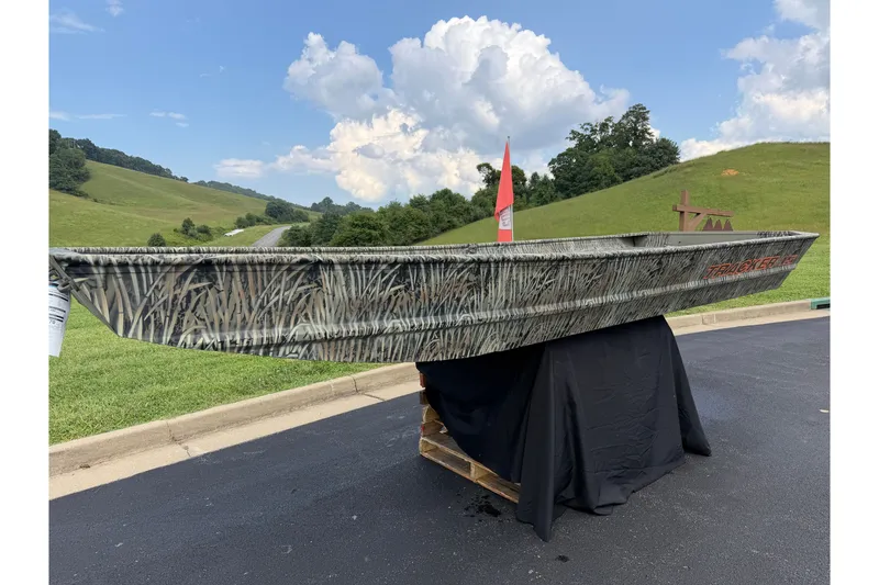 The Image of 2026 Tracker Grizzly 15 Jon boat with camouflage design on display outdoors. - 0