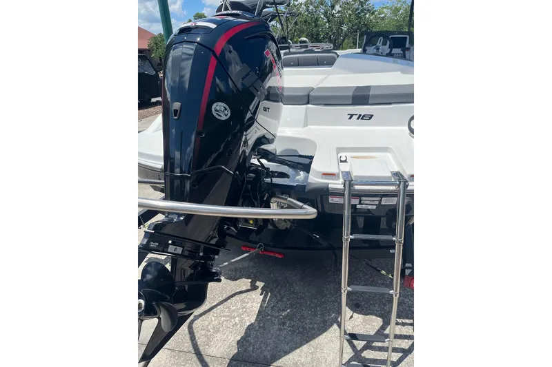 Slide: The Image of 2026 Tahoe T18 boat with outboard motor and ladder, parked outdoors. - 5