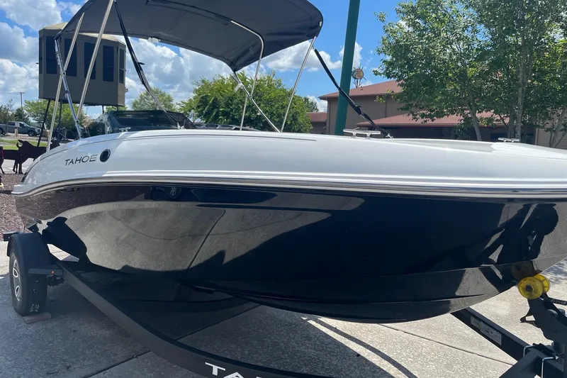 Slide: The Image of 2026 Tahoe T18 boat on trailer, parked outdoors under a clear sky. - 1