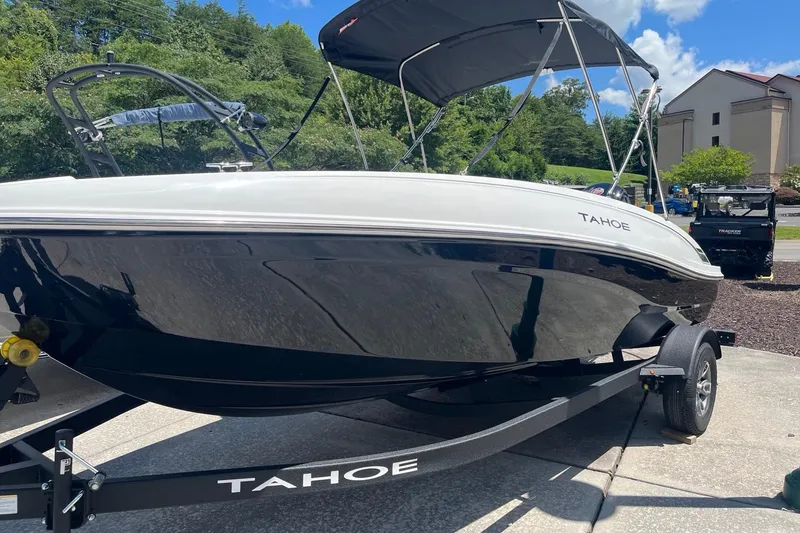 The Image of 2026 Tahoe T18 boat on trailer, sleek design, black and white finish, outdoor setting. - 0