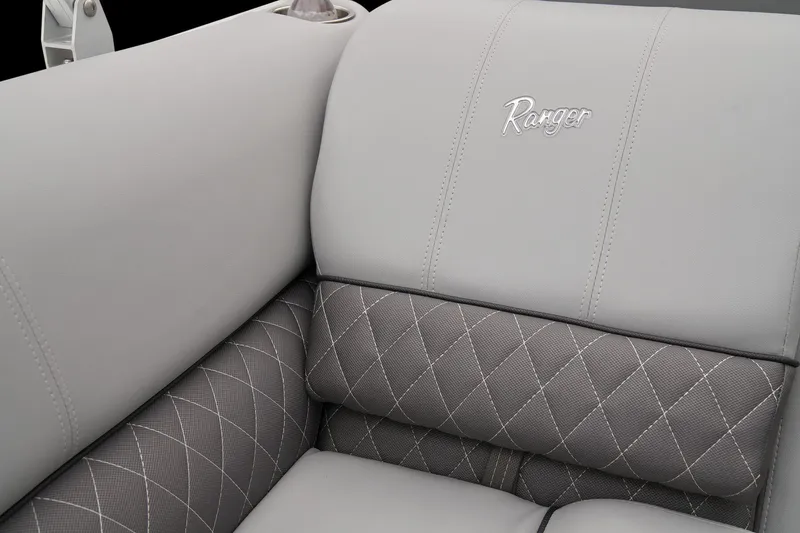 Slide: The Image of 2025 Ranger Reata 243C boat interior with open storage compartment and cushioned seating. - 27