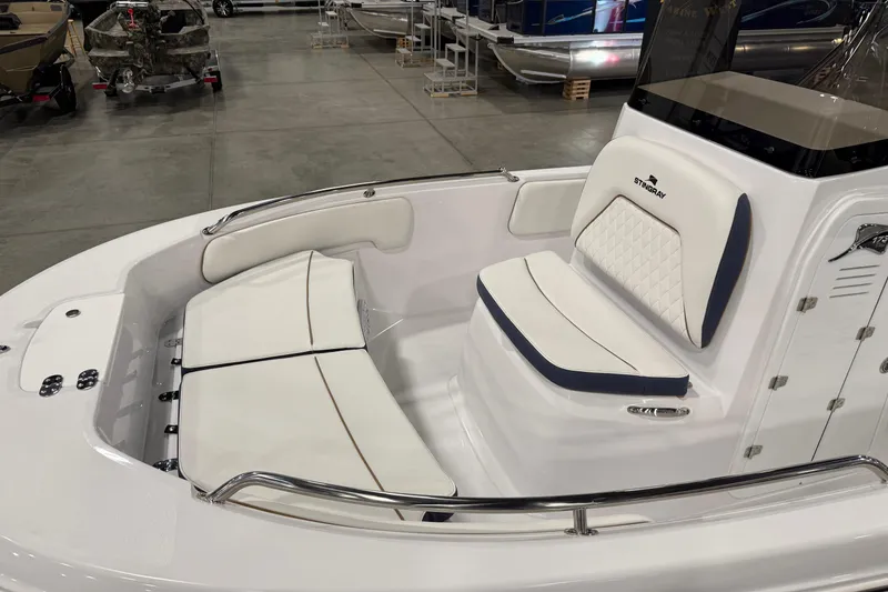 Slide: The Image of 2026 Stingray 173 CC boat interior with white cushioned seating and sleek design. - 2