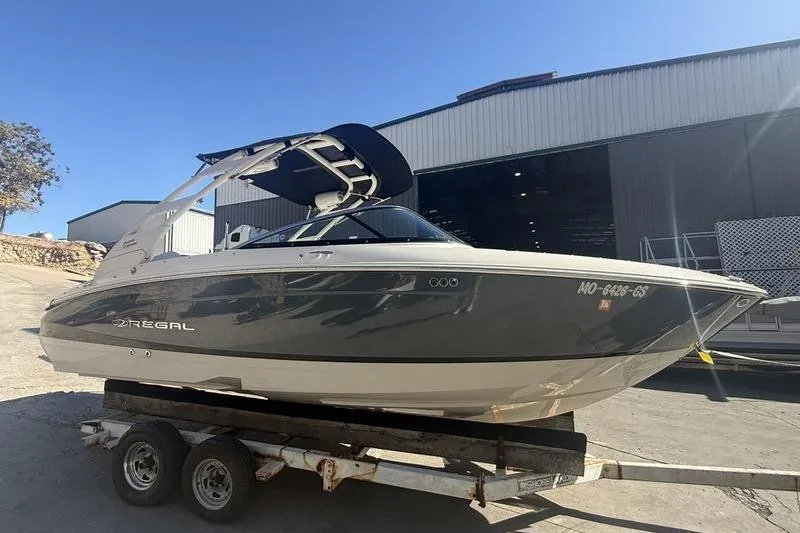 Slide: The Image of 2023 Regal LS4 Surf boat on trailer outside a warehouse. - 10