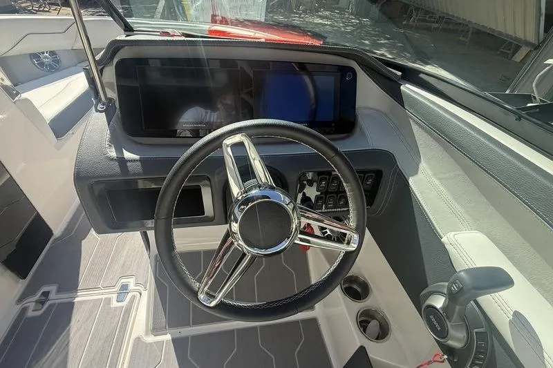 Slide: The Image of 2023 Regal LS4 Surf boat dashboard with steering wheel and control panel. - 12