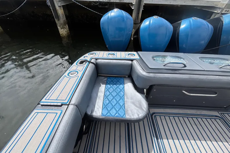 Slide: The Image of 2016 Hydra-Sports 4200 Siesta boat interior with blue accents and seating near water. - 57
